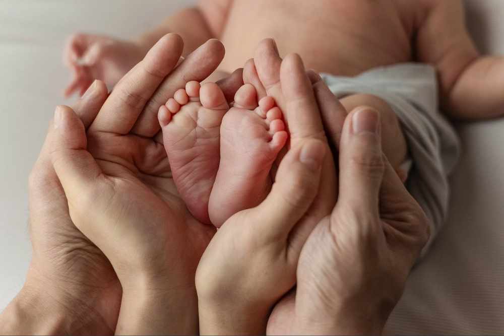 아기의 두 발을 손으로 감싼 모습