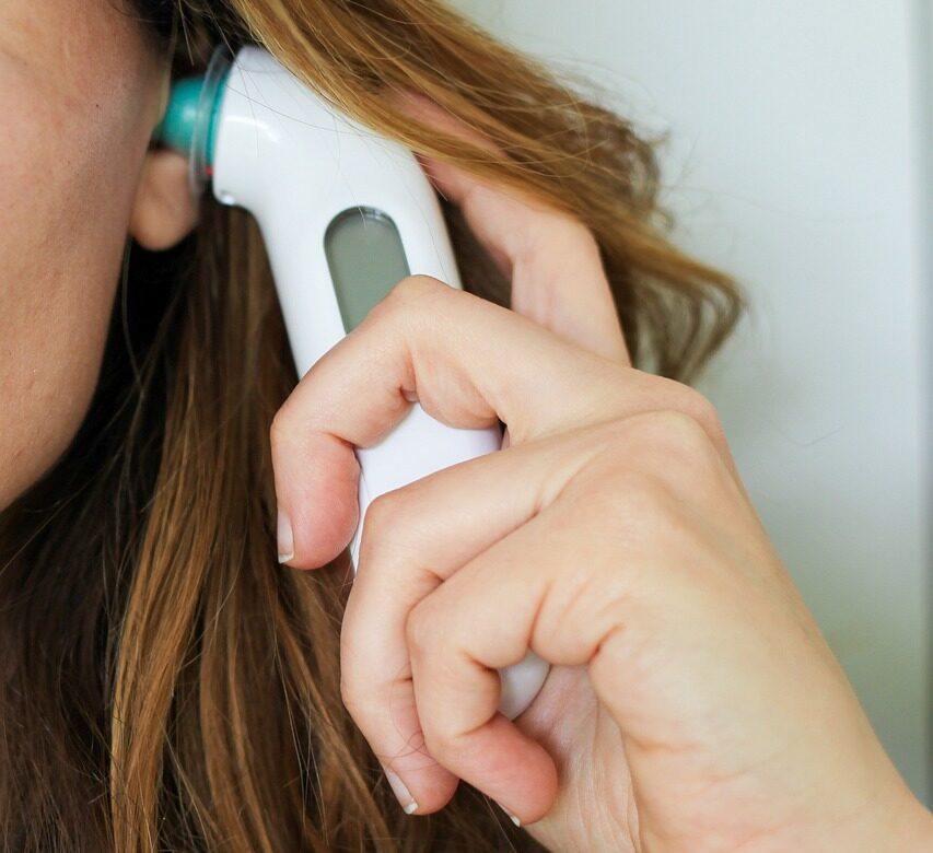 체온계로 체온을 재는 여성